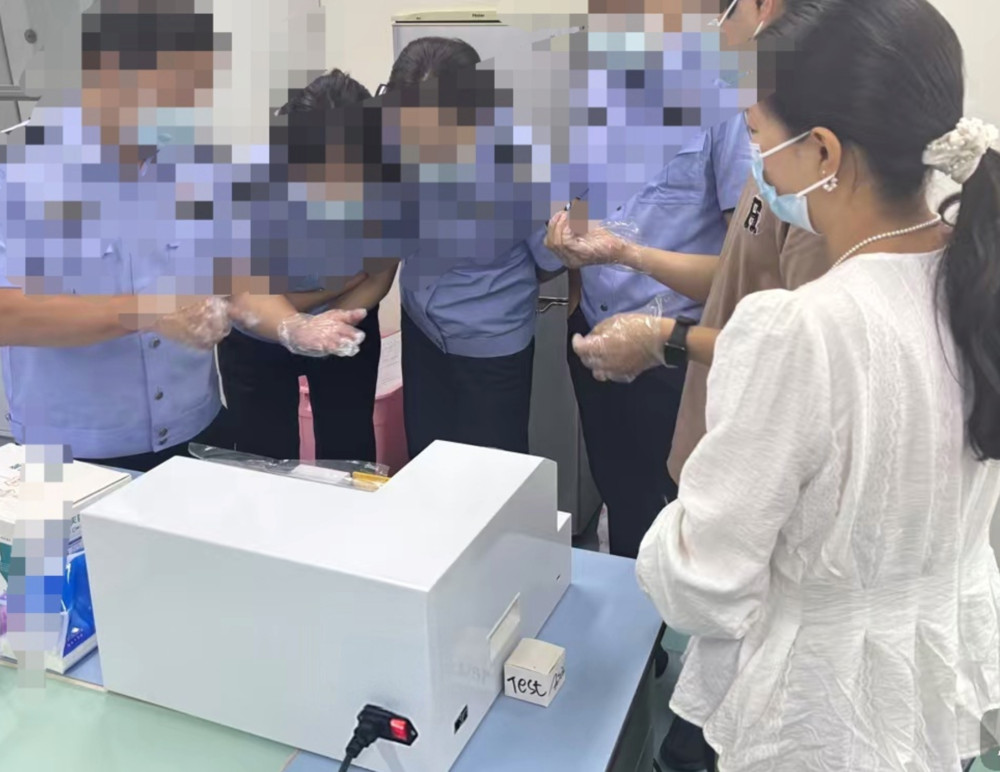 Several police technicians are watching a demonstration of the machine's operation.